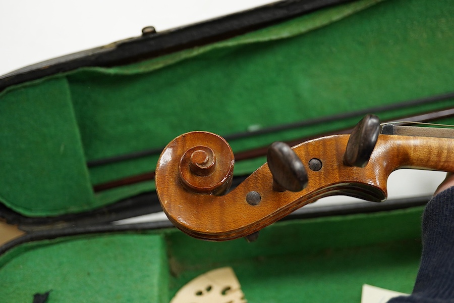 Four cased violins; an early 20th century violin, body 36cm, fitted with a microphone pick up taking a quarter inch jack plug, an early 20th century half size violin, body 32cm, and two student violins. Condition - poor